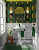Bathroom with a green and yellow patterned wallpaper, white sink, and green towel.