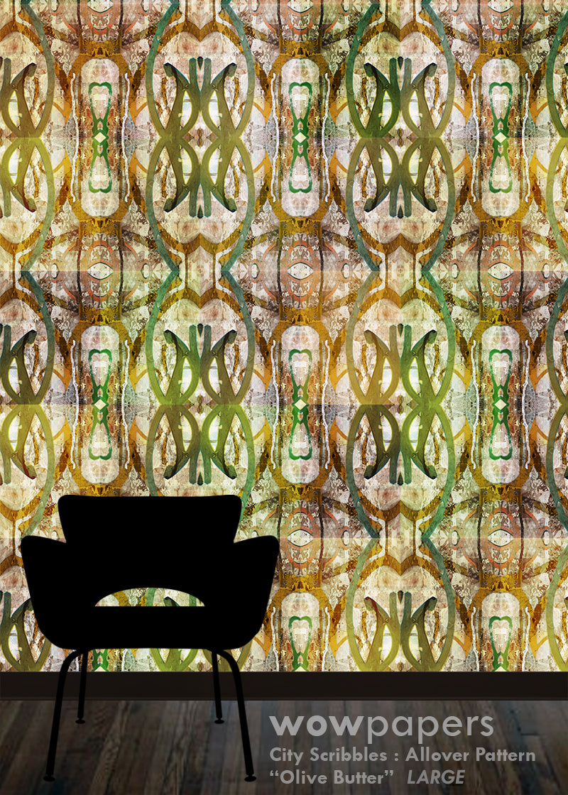 A large-scale wallpaper pattern featuring an abstract, vintage-style allover design in olive green, gold, beige, and brown tones. A black silhouette of a modern armchair is shown in the foreground against the patterned wall, with a dark wood floor at the bottom.